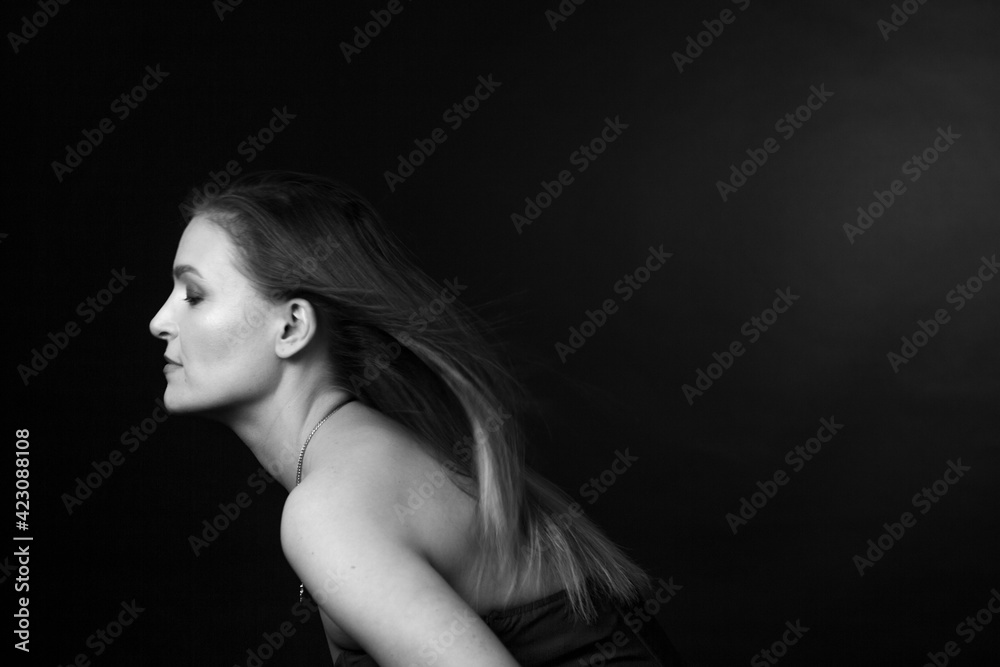 black and white portrait of an adult woman in a studio on black background. black and white portrait of an adult woman in a studio on black background.