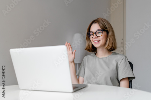 young relaxed caucasian woman smiling sitting with laptop in the apartment © Anastasia