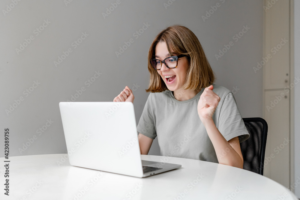 young winning caucasian woman taring at laptop in the apartment young winning caucasian woman taring at laptop in the apartment