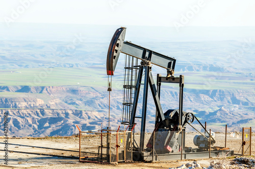 View of the pumpjack in the oil well. A pump jack is a device used in the petroleum industry to extract crude oil from an oilfield.