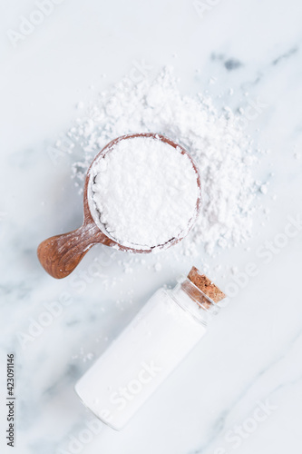 white powder in scoop with glass vial photo