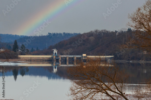 Water area and dam of a dam reservoir in the city of Brno in the Czech Republic in Europe. There is a rainbow in the sky.