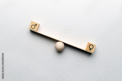 Foto Feminine dominance concept on abstract scales with masculine and Gender icons