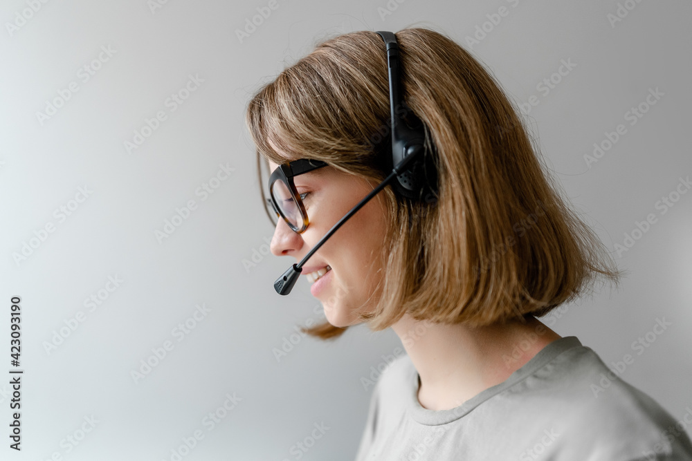 Caucasian woman working with headset answering business calls as tech support dispatcher isolated copyspace