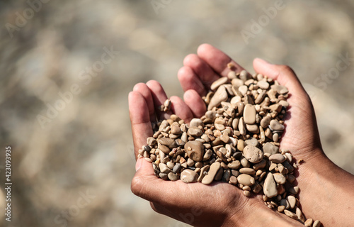 Little stones in hands at a Croatian beach. Heart shape 