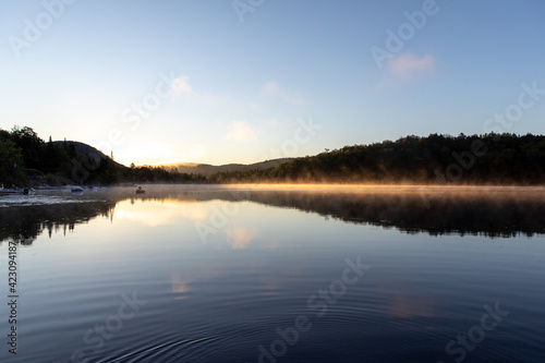 vue d'un cygne gonflable qui flotte sur un lac calme lors d'un lever de soleil