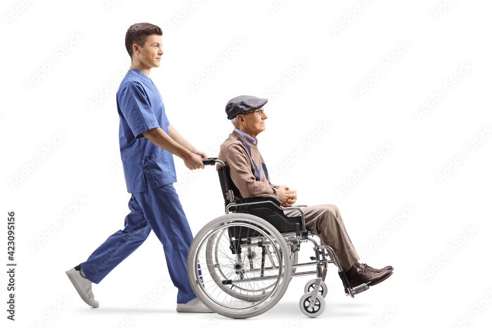 Full length profile shot of a male nurse pushing a elderly man in a ...