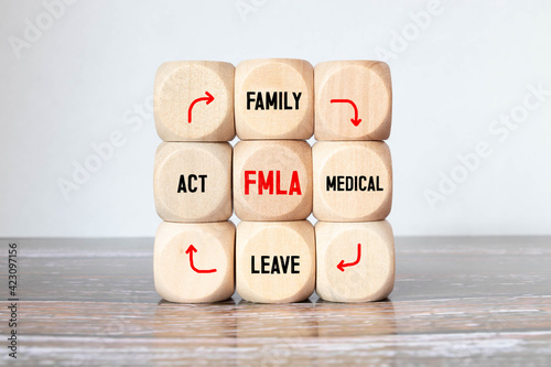 FMLA symbol. Concept words 'FMLA, family medical leave act' on wooden cubes.