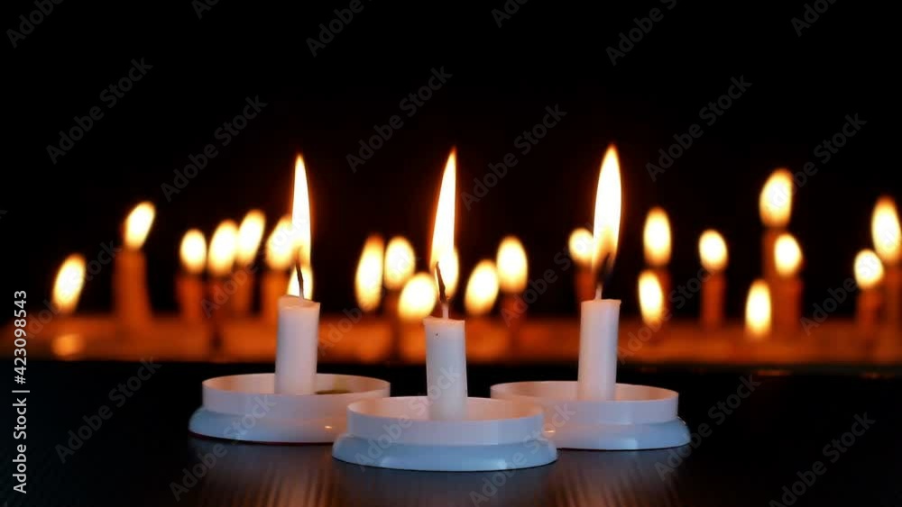 Close up candles flame Isolated on black shiny paper candlelight blurred on dark Background.
Close up candles flame Isolated on black shiny paper candlelight blurred on dark Background.