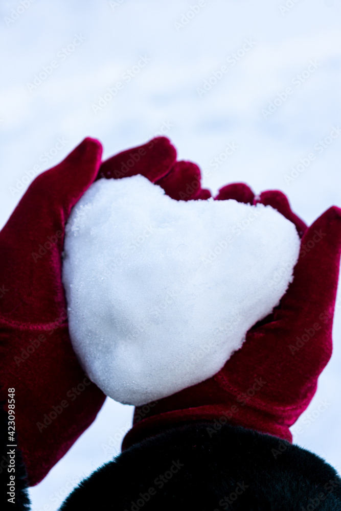 Holding a heart shaped snow ball