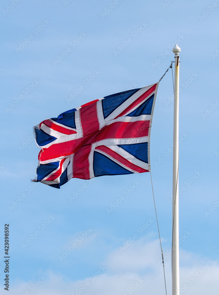 The national flags of the Great Britain Union Jack on the background of blue sky The national flags of the Great Britain Union Jack on the background of blue sky