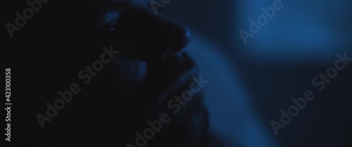 Close up of a soldier sitting alone in a dark room, staring to nowhere, dealing with PTSD.