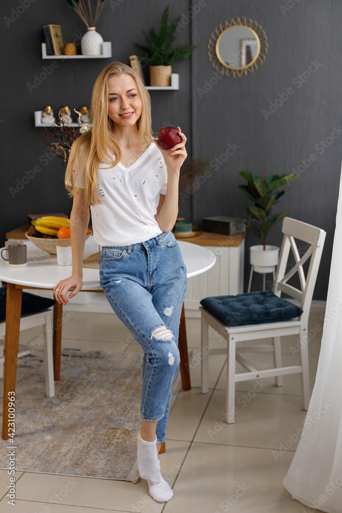 attractive healthy woman with an apple at home at the table attractive healthy woman with an apple at home at the table