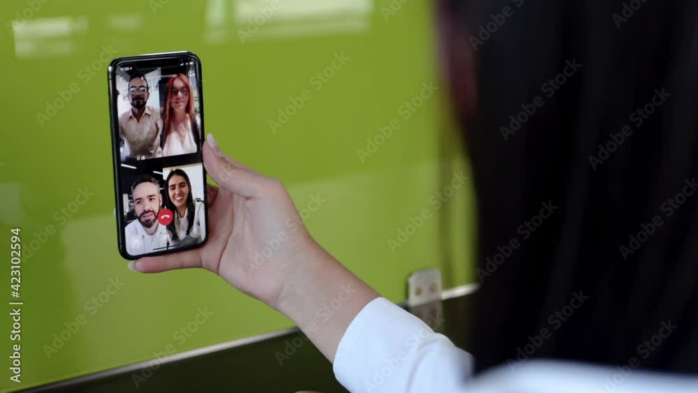 Detalle mano de mujer en videollamada con amigos