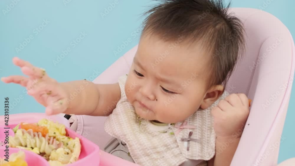 4K Close up slow motion Asian baby eating soft food by hand on baby chair 4K Close up slow motion Asian baby eating soft food by hand on baby chair