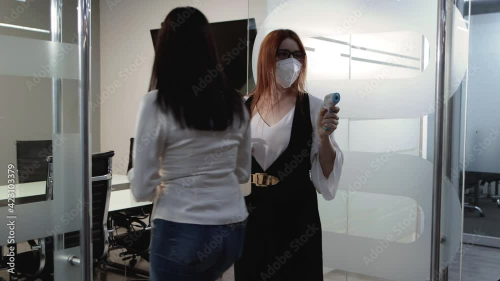 Mujer toma temperatura en oficina  