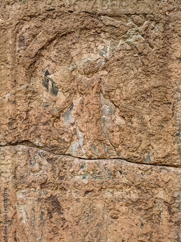 old stone wall with carved religious weathered image