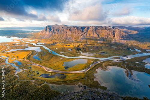 Beautiful, wild arctic valley viewed from mountain top in epic early morning light. Remote Rapa river valley from the top of Skierfe in Sarek national park in Swedish Lapland. Autumn colors. photo