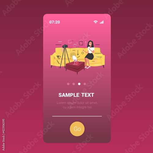 beauty blogger applying lipstick woman showing trend makeup tutorial recording online video with camera on tripod blogging concept mobile app copy space full length