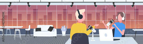 podcasters talking to microphones recording podcast in studio podcasting online radio concept man in headphones interviewing woman broadcasting portrait horizontal