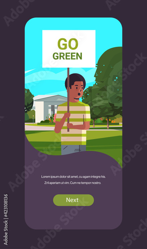 environmental activist holding poster go green save planet strike concept male protester campaigning to protect earth demonstrating against global warming portrait mobile app vertical copy space