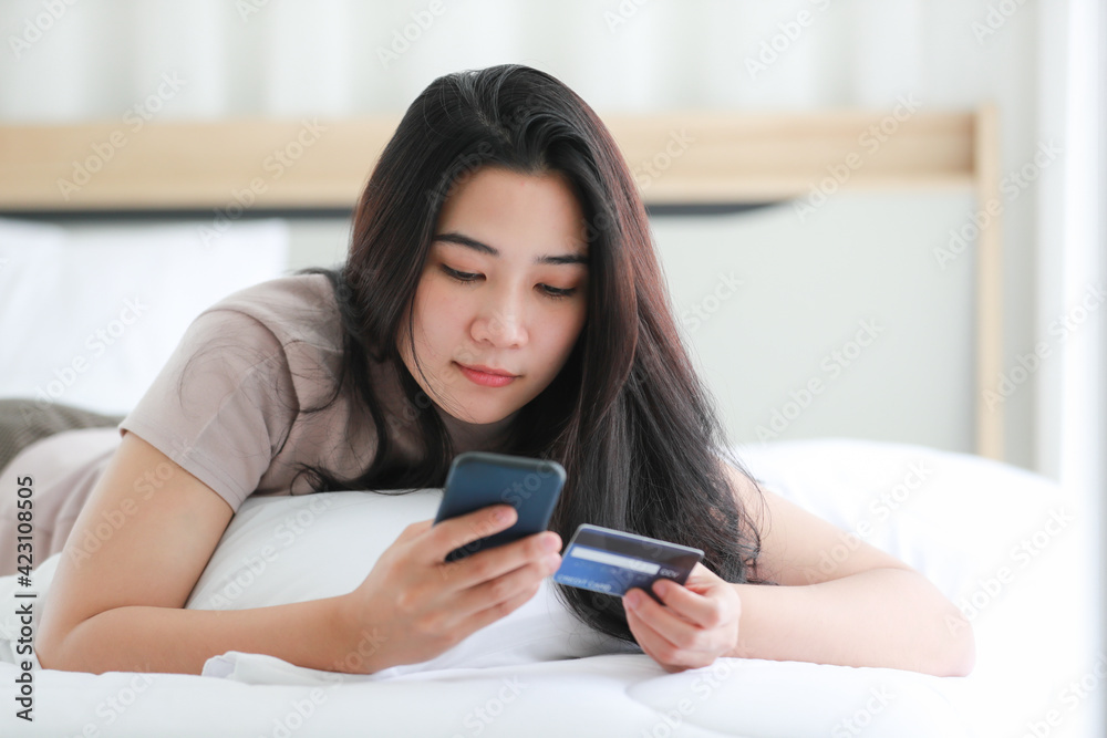 Woman using telephone on bed in bedroom. Woman using telephone on bed in bedroom.
