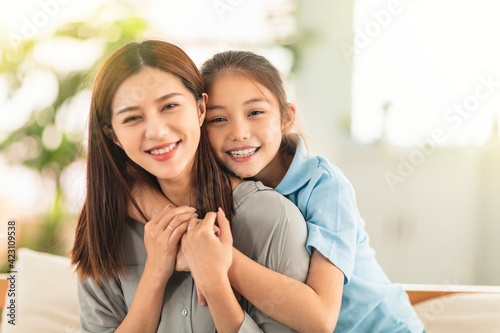 Happy mother and little girl daughter having fun at home