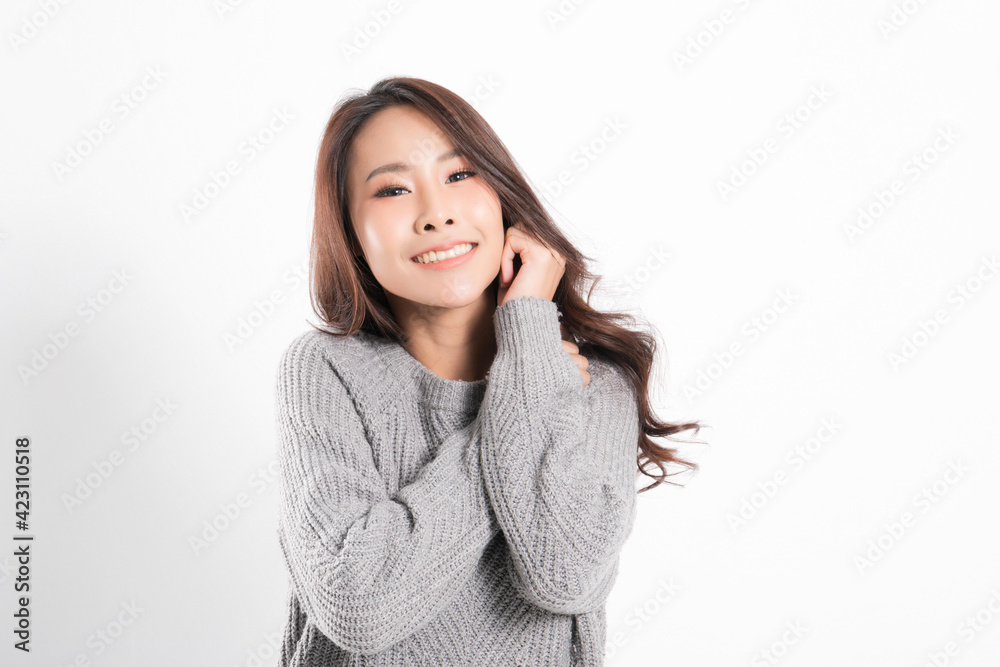 Pretty smiling joyfully being happy asian woman portrait with perfect skin and wearing a gray sweater in profile at studio shot isolated on white background. Pretty smiling joyfully being happy asian woman portrait with perfect skin and wearing a gray sweater in profile at studio shot isolated on white background.