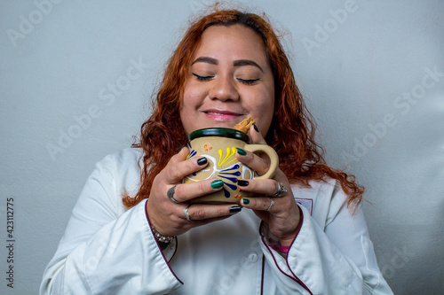 Happy Mexican woman, drinking a cup of coffee. latin cook