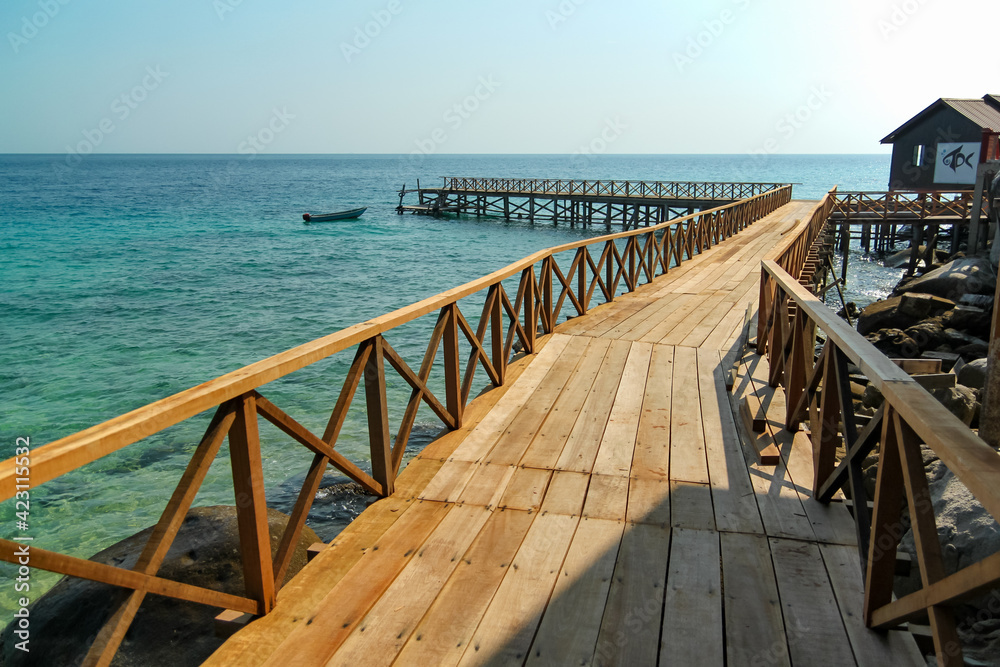 Wooden bridge pier along the seashore with turquoise water
