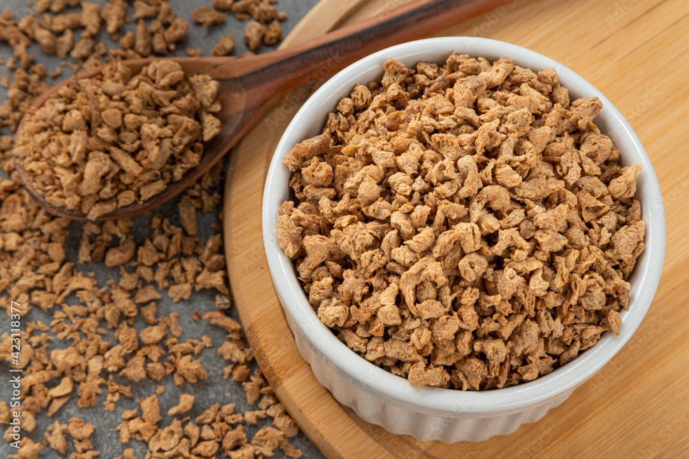 Bowl with soy protein grains. Detail of wooden spoon and bamboo holder. Bowl with soy protein grains. Detail of wooden spoon and bamboo holder.