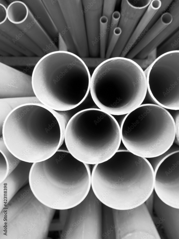 Multi size pvc pipe on the metal rack in black and white Multi size pvc pipe on the metal rack in black and white