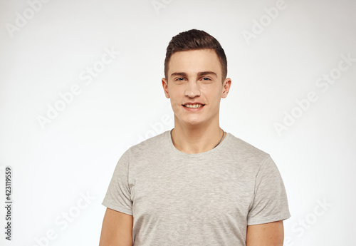 Cheerful emotional man in a T-shirt attractive appearance light background