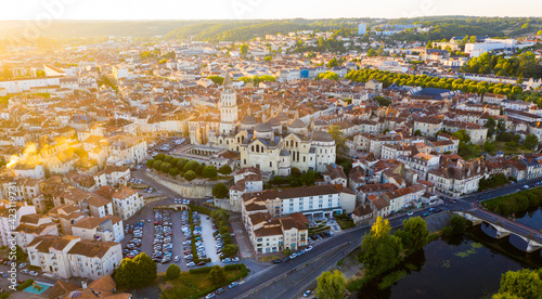 Scenic summer landscape of Perigueux with medieval Catholic Cathedral on bank of Isle river at sunset, France