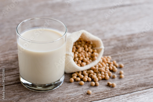 Glass of soy milk isolated on wooden table background. 