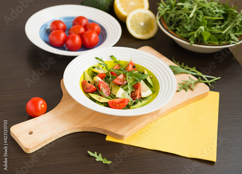 Healthy food. Fresh salad of arugula with cherry tomatoes and avocado.
