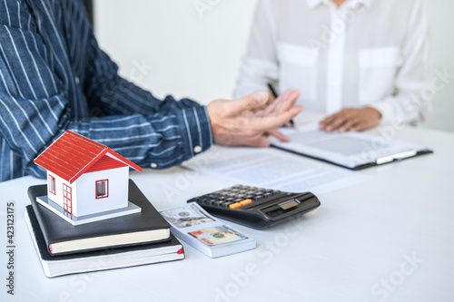 Real estate broker agent being analysis and making the decision a home estate loan to customer to signing contract documents for realty purchase, Bank employees recommend mortgage loan approval