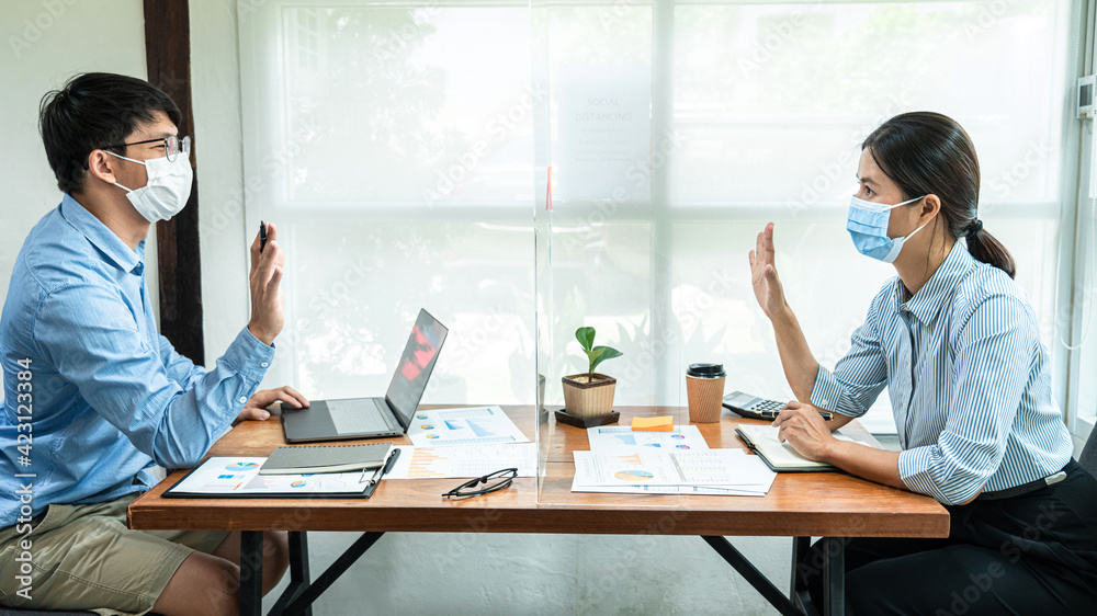 Two business colleagues wearing face mask to brainstorming business project and giving high five to each other Two business colleagues wearing face mask to brainstorming business project and giving high five to each other