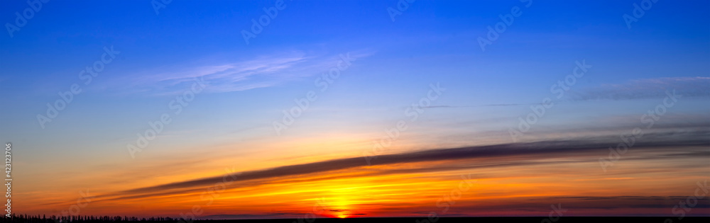 Bright blue and orange sky in the morning. Sunrise on the horizon. Blur clouds and background.
