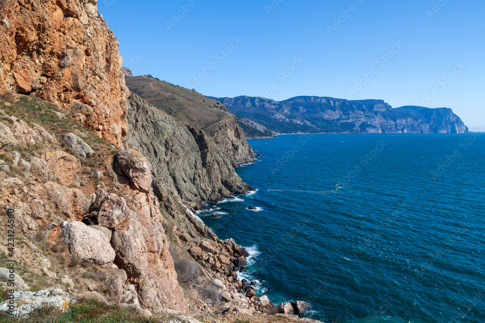 View of the Black Sea coast in Crimea, Cape Fiolent in Sevastopol. Panoramic seascape, calm azure sea, clouds and bright sky.