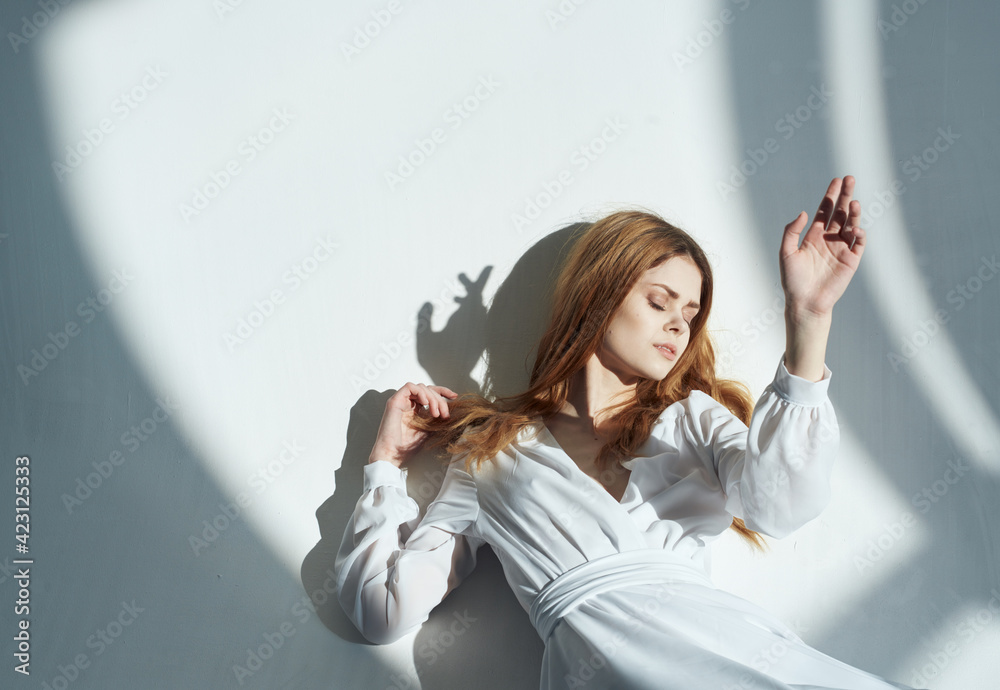 Naklejka premium Romantic woman model leaning against the wall indoors and falling shadow