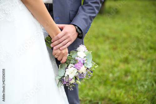 wedding bouquet and newlyweds hands