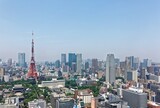 Beautiful city skyline of Downtown Tokyo, with the famous landmark Tokyo Tower standing tall among crowded skyscrapers under blue sunny sky in Tokyo, Japan ~ Aerial view of busy Tokyo Downtown