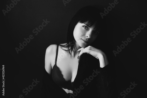 black and white portrait of a brunette girl in a black dress and lingerie