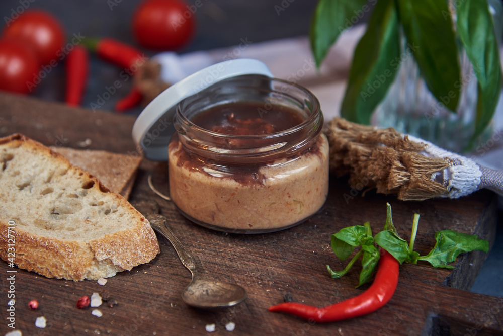 Handmade chicken pate in a glass jar on a wooden board . Handmade chicken pate in a glass jar on a wooden board .