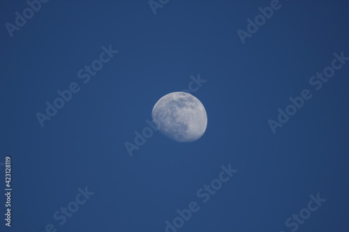The full moon over blue sky