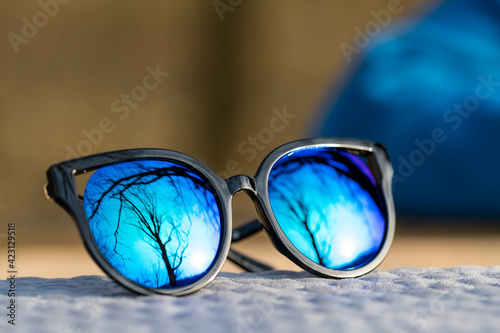 Fototapeta Naklejka Na Ścianę i Meble -  Fashion cat eye sunglasses model for ladies with big blue lenses and black frame shoot outside in a sunny day closeup. Selective focus . High quality photo