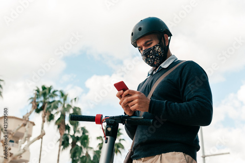 Man driving an electric scooter in the city wearing mask