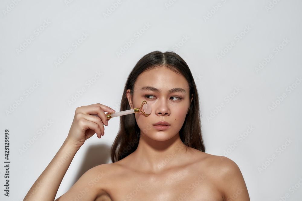 Girl looking to the side while taking care of skin Girl looking to the side while taking care of skin