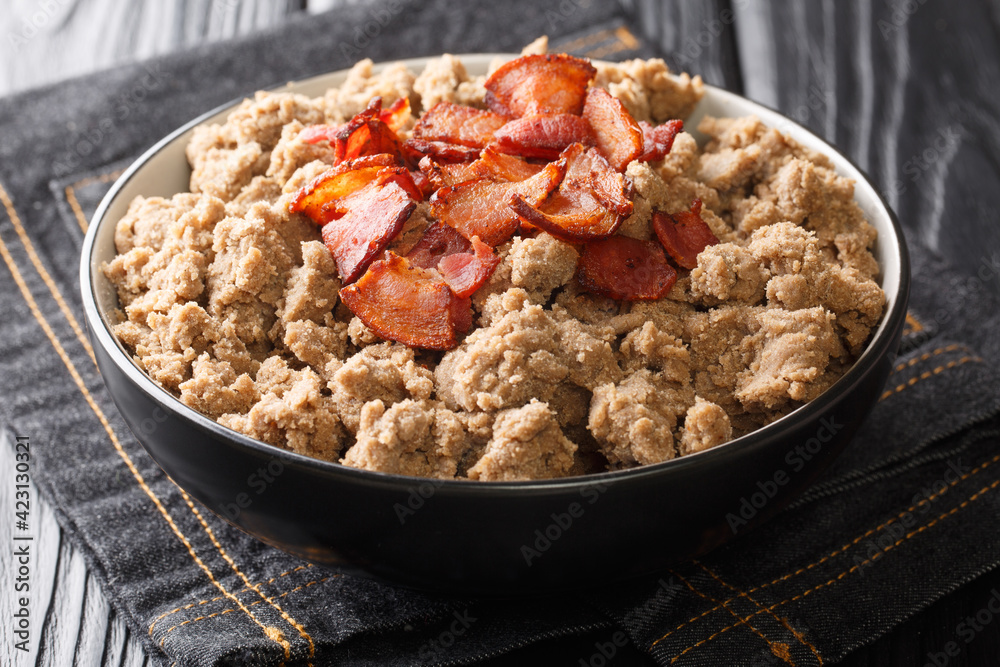Rustic style Ajdovi zganci Slovenian buckwheat porridge served with cracklings close-up in a bowl on the table. horizontal Rustic style Ajdovi zganci Slovenian buckwheat porridge served with cracklings close-up in a bowl on the table. horizontal